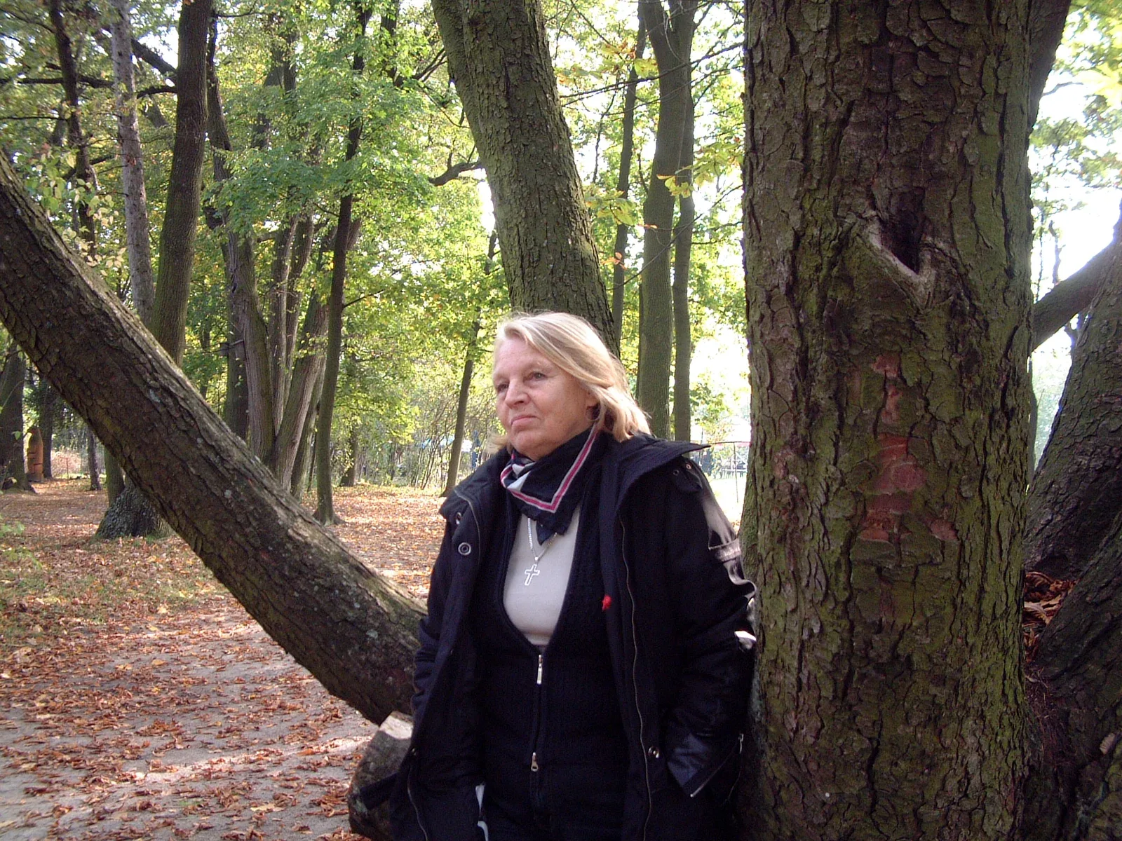Antonina in piedi accanto a un grande albero, in un viale di parco autunnale, 2007
